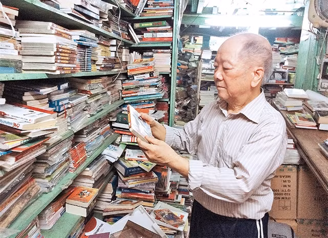 Ông Luy, chủ quán sách số 5 Ðinh Lễ giới thiệu sách với bạn đọc.