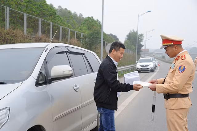 Cán bộ Cục CSGT (Bộ Công an) nhắc nhở lái xe tham gia giao thông trên đường cao tốc Nội Bài - Lào Cai dừng, đỗ xe đúng nơi quy định.