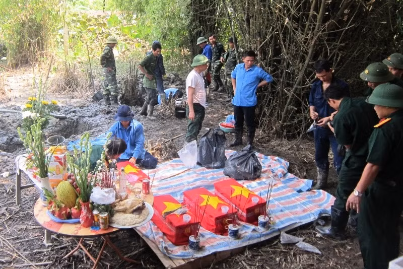 Lực lượng chức năng cất bốc phần mộ, hài cốt các liệt sĩ.
