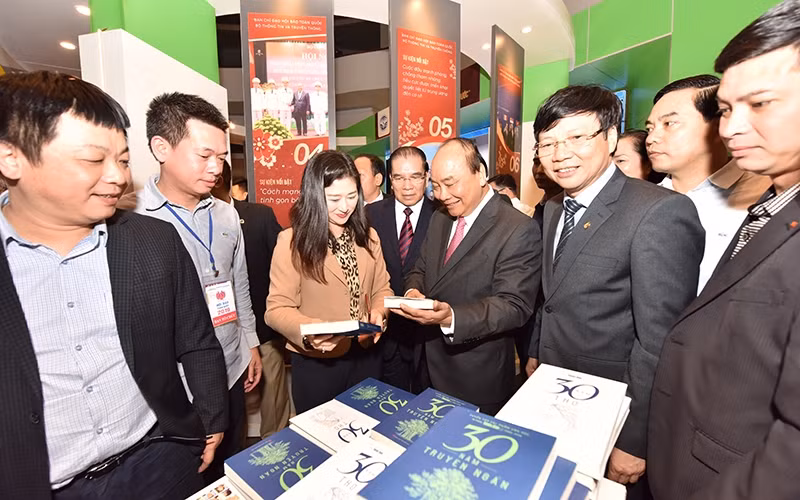 Thủ tướng Nguyễn Xuân Phúc thăm gian trưng bày của Báo Nhân Dân tại Hội báo toàn quốc năm 2019. Ảnh: Duy Linh.
