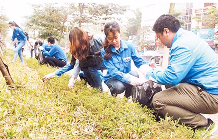 Đoàn viên, thanh niên quận Hai Bà Trưng dọn vệ sinh môi trường trên phố Thanh Nhàn. Ảnh: PHƯƠNG THANH