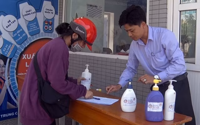Người dân đến nhận dung dịch rửa tay diệt khuẩn do thầy trò Trường Cao đẳng Công nghiệp Huế pha chế.