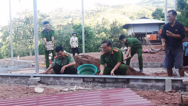 Cán bộ, chiến sĩ Công an huyện Mường Nhé và người dân bản Huổi Hốc chung tay làm nhà cho anh Sủng A Sùng.