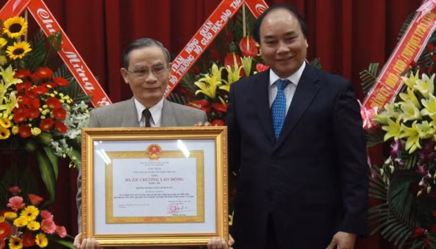 Phó Thủ tướng Nguyễn Xuân Phúc (bên phải) trao Huân chương Lao động hạng nhì cho lãnh đạo Trường đại học Dân lập Duy Tân.