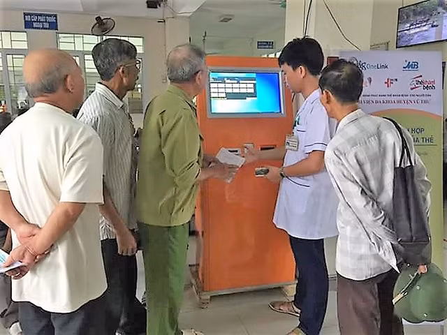 Cán bộ y tế Bệnh viện đa khoa huyện Vũ Thư hướng dẫn người dân sử dụng thẻ khám, chữa bệnh thông minh.