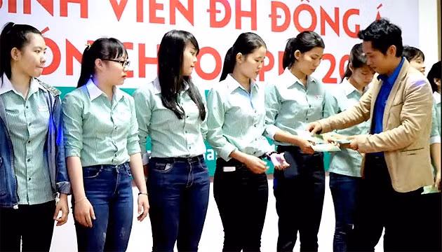 Đại diện đoàn Trường ĐH Đông Á trao vé xe về quê đón Tết cho các sinh viên vùng lũ.