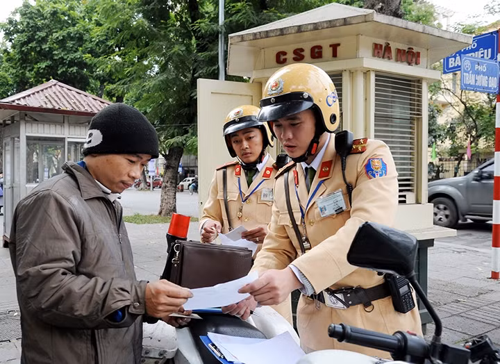 Cán bộ, chiến sĩ Ðội cảnh sát giao thông số 1, Phòng CSGT đường bộ - đường sắt (Công an TP Hà Nội) xử phạt người vi phạm giao thông. Ảnh: KHÁNH AN