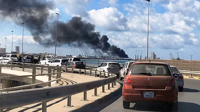 Khói đen bốc lên từ cảng Tripoli sau cuộc tiến công của LNA. Ảnh: FRANCE24