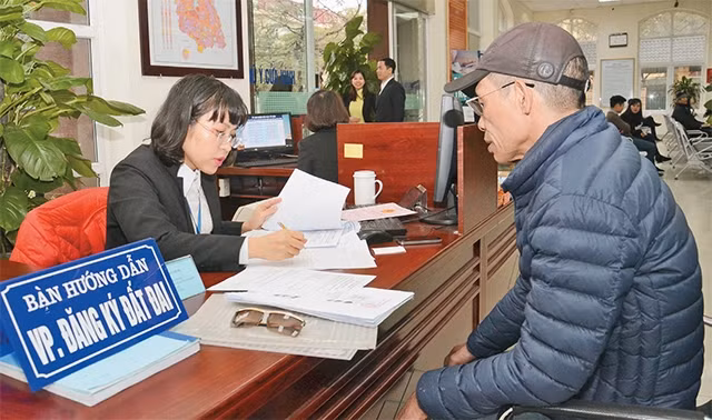 Cán bộ bộ phận "một cửa" UBND quận Nam Từ Liêm hướng dẫn người dân đến làm thủ tục hành chính.