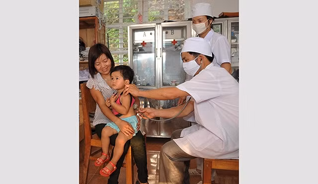 Cán bộ Trạm y tế xã Chiềng Ơn, huyện Quỳnh Nhai (Sơn La) khám, chữa bệnh cho trẻ em. Ảnh: NGUYỄN ĐĂNG