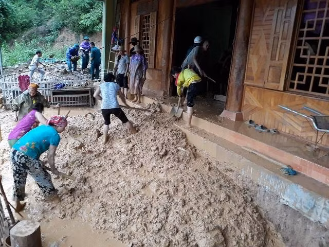 Bộ đội Biên phòng giúp dân vệ sinh môi trường, nạo vét bùn đất ra khỏi nhà ở.