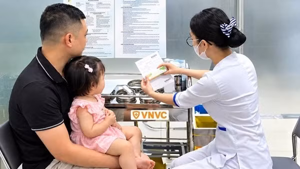 Nhân viên y tế tư vấn cho gia đình trước khi thực hiện tiêm vaccine tay chân miệng. (Ảnh: VNVC)