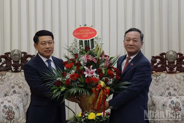 Đại sứ Nguyễn Minh Tâm chuyển lẵng hoa của Thủ tướng Lê Minh Hưng chúc mừng Thủ tướng Lào Saleumxay Kommasith. (Ảnh: DUY TOÀN)