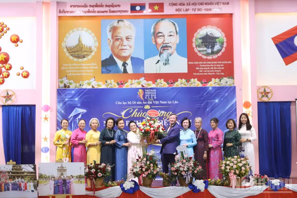 Đại sứ Việt Nam tại Lào Nguyễn Minh Tâm tặng hoa chúc mừng ngày 20/10 tại chương trình. (Ảnh: TRỊNH DŨNG)