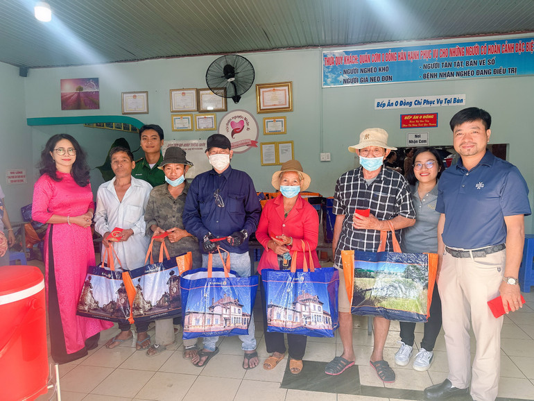 Chủ tịch Ủy ban nhân dân huyện Xuyên Mộc Lê Thị Trang Đài (áo dài đỏ ngoài cùng) trao quà cho người nghèo.