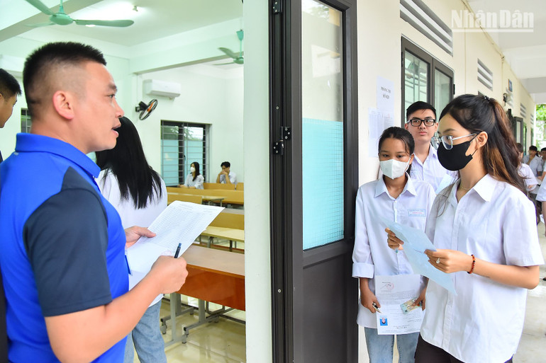 Cán bộ coi thi gọi thí sinh vào phòng thi tại điểm thi Trường THPT Lê Hồng Phong.