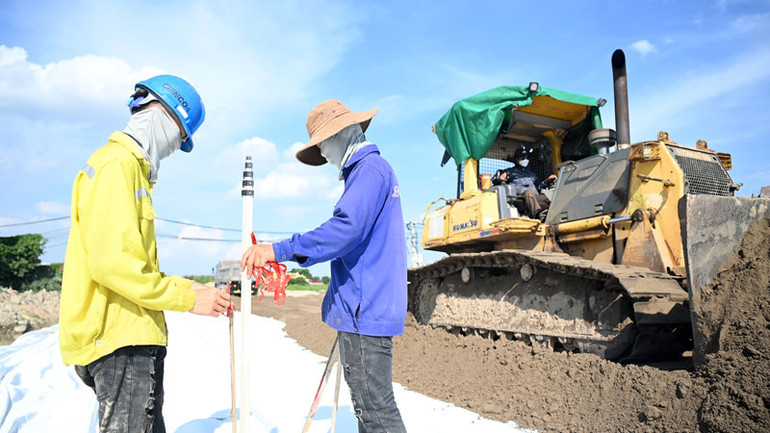 Công nhân đang xử lý nền đất yếu trên công trường thi công đường song hành thuộc dự án đường Vành đai 4-Vùng Thủ đô, đoạn trên địa bàn huyện Thanh Oai, Hà Nội. (Ảnh: Thủy Nguyên)
