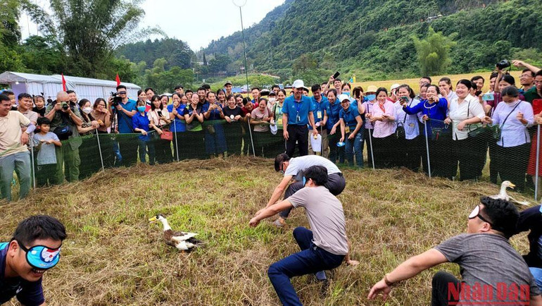 Du khách tham gia trò chơi bịt mắt bắt vịt.
