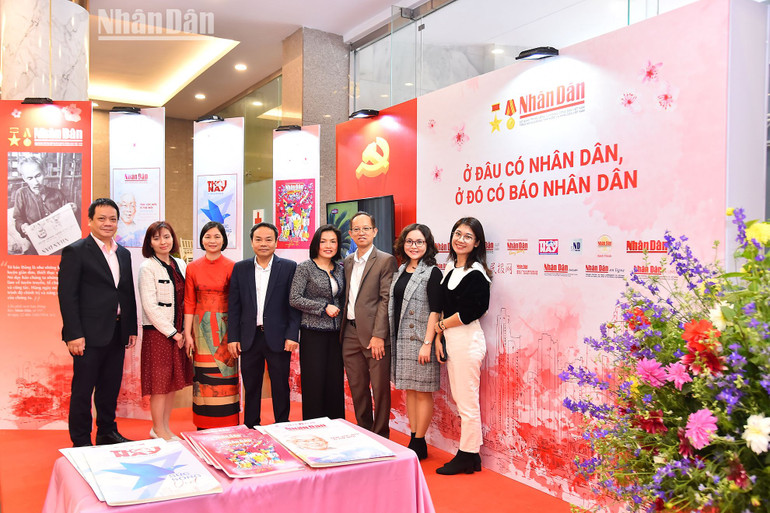 Các đồng chí lãnh đạo, cán bộ, phóng viên, biên tập viên Báo Nhân Dân tại gian trưng bày của Báo Nhân Dân tại hội báo.