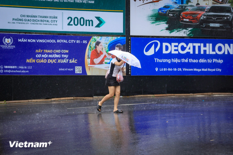 Người đi bộ cũng di chuyển khó khăn vì gió lớn.