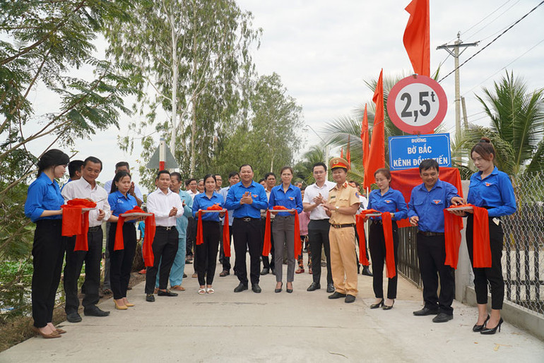 Các đại biểu cắt băng khánh thành công trình Thắp sáng đường quê tại ấp A, xã Phú Cường.