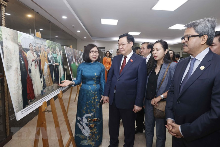 Bà Đoàn Thị Tuyết Nhung, Phó Tổng Giám đốc Thông tấn xã Việt Nam giới thiệu ảnh của phóng viên TTXVN cho Chủ tịch Quốc hội Vương Đình Huệ và đại biểu tại buổi Trưng bày ảnh. (Ảnh: Doãn Tấn/TTXVN)