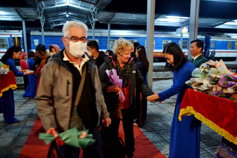 Buộc chỉ cổ tay và tặng hoa cho du khách chúc mừng năm mới thành công. Buộc chỉ cổ tay và tặng hoa cho du khách chúc mừng năm mới thành công.