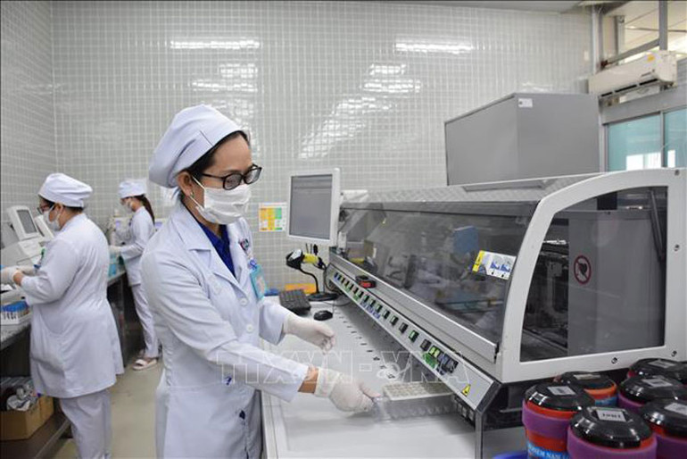Nhân viên y tế Bệnh viện Chợ Rẫy vận hành hệ thống máy xét nghiệm.
