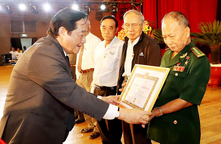 Đồng chí Nguyễn Hoàng Thao (trái) trao Huy hiệu Đảng tặng các đảng viên.