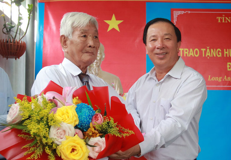 Đồng chí Nguyễn Văn Út, Phó Bí thư Tỉnh ủy, Chủ tịch Ủy ban nhân dân tỉnh Long An trao Huy hiệu 65 tuổi Đảng cho đồng chí Đặng Văn Bầu tại nhà riêng.