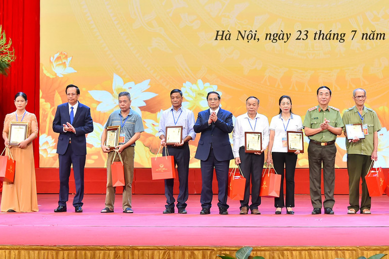 Thủ tướng Phạm Minh Chính và các đồng chí lãnh đạo trao kết quả giám định mẫu hài cốt cho đại diện 10 gia đình liệt sĩ.