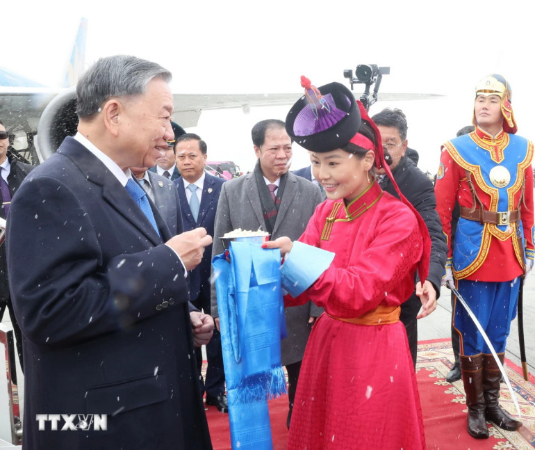 Thiếu nữ Mông Cổ dâng bánh sữa theo phong tục truyền thống và tặng hoa đón Tổng Bí thư, Chủ tịch nước Tô Lâm tại sân bay Thành Cát Tư Hãn (Chinggis Khaan International Airport) ở Thủ đô Ulan Bator. Ảnh: Trí Dũng/TTXVN