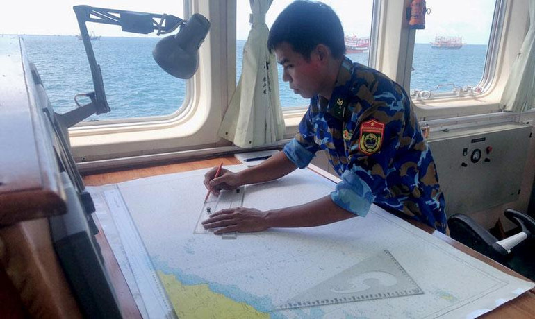 Chiến sĩ Bộ đội Biên phòng trên tàu tìm kiếm cứu nạn CN09 đang xác định tọa độ trên hải đồ khu vực tìm kiếm tàu cá bị mất liên lạc.