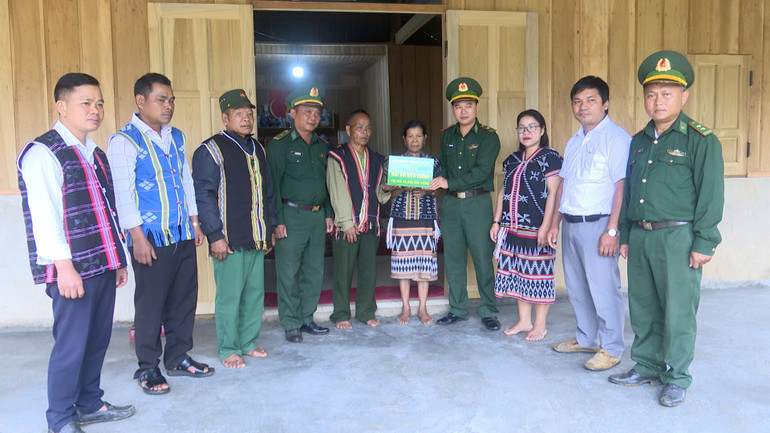 Thiếu tá Nguyễn Đức Vỹ, Phó Bí thư Đảng ủy xã Tr’hy (đứng thứ 4 bên trái) cùng đồn Biên Phòng trao mái ấm biên cương cho người dân biên giới.