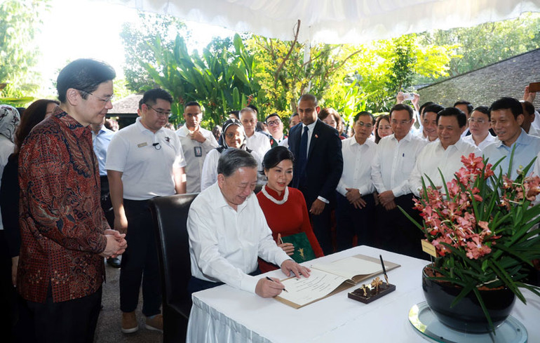 Tổng Bí thư Tô Lâm ghi lưu bút tại Vườn Thực vật Singapore. (Ảnh: Thống Nhất/TTXVN)