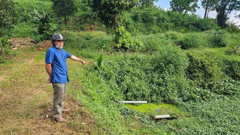 Ông Phạm Văn Triều, Trưởng thôn Long Tiến, đứng bên hồ chứa nước cạnh trại lợn. ong-pham-van-trieu-truong-thon-long-tien-xa-cam-long-huyen-cam-thuy-tinh-thanh-hoa.jpg