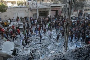 Người dân Palestine đứng giữa đống đổ nát của những tòa nhà bị phá hủy sau đòn không kích của Israel tại khu vực Al-Rimal, phía tây thành phố Gaza ngày 30/8/2025. (Ảnh: THX/TTXVN) 