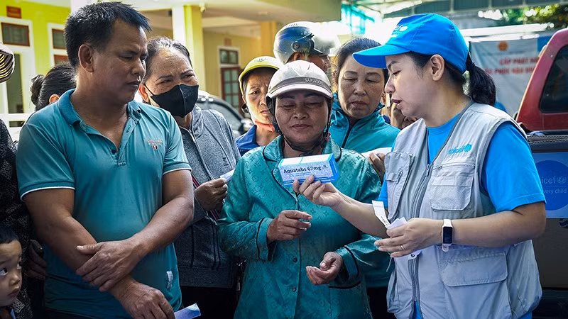 Cán bộ của UNICEF với người dân ở vùng bị ảnh hưởng bởi lũ lụt, sạt lở đất do hoàn lưu của bão số 3. (Ảnh UNICEF)