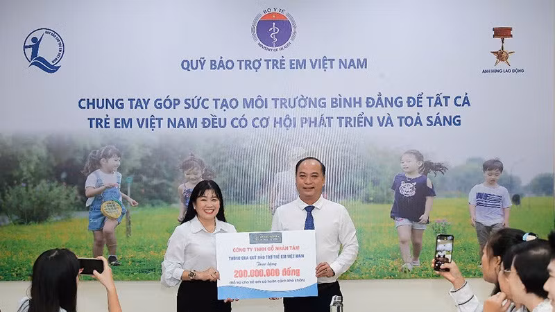 Đại diện Quỹ Bảo trợ trẻ em Việt Nam nhận bảng tượng trưng kinh phí hỗ trợ trẻ em từ Công ty Gỗ Nhân Tâm.