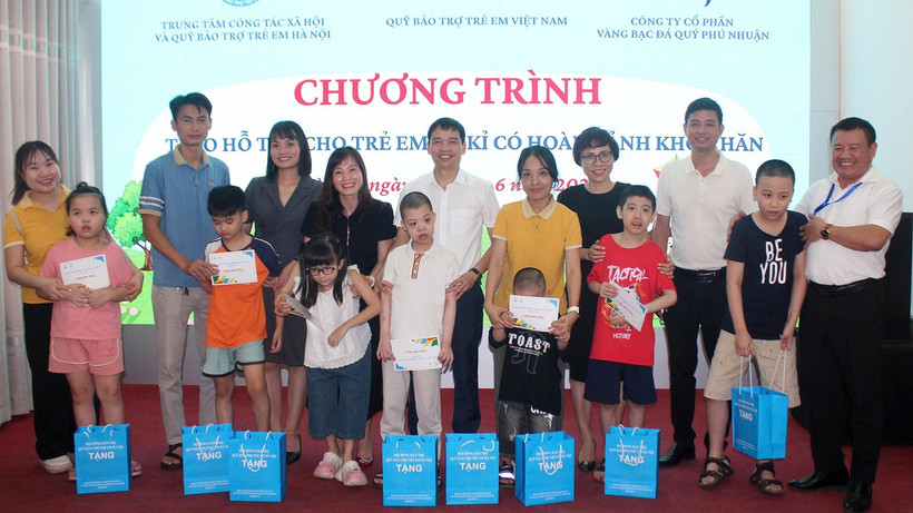 Các đại biểu trao hỗ trợ cho trẻ tự kỷ có hoàn cảnh khó khăn tại Hà Nội. (Ảnh NFVC)