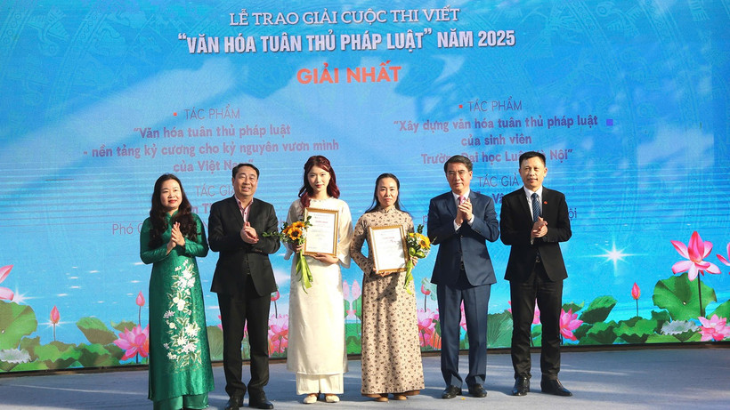 Các đại biểu và đại diện Ban tổ chức trao giải cho hai tác giả đoạt giải Nhất của cuộc thi.