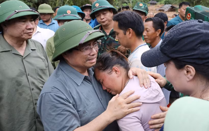 Thủ tướng chia sẻ với nỗi đau mất người thân của người dân vùng lũ quét. (Ảnh TTXVN)