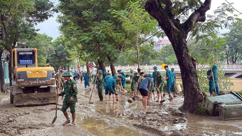 Bộ đội Biên phòng thành phố Huế cùng với lực lượng chính quyền địa phương dọn dẹp tại đường Phan Chu Trinh, phường Thuận Hóa. (Ảnh: VGP)