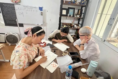 Trịnh Đỗ Hồng Thủy (giữa) hướng dẫn cho người tập viết.