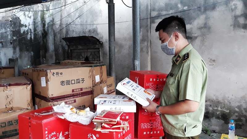 Cán bộ quản lý thị trường kiểm tra chất lượng sản phẩm bánh, kẹo nhập khẩu. (Ảnh: NGUYÊN TRANG)