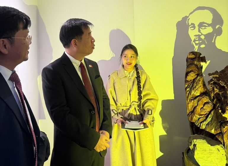 השגריר וו הו עומד ליד תצלום של הנשיא הו צ'י מין המוצג בתערוכה. (צילום: שגרירות וייטנאם בדרום קוריאה) trienlam3.jpg