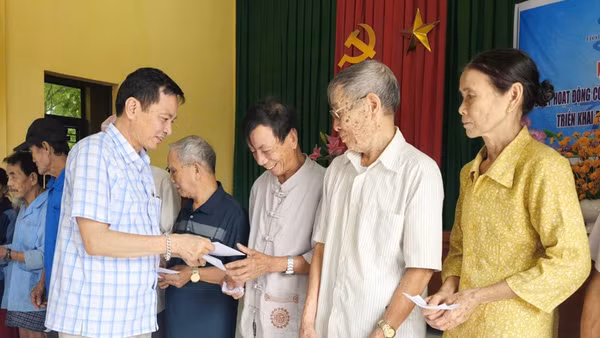 Đại diện Báo Nhân Dân tại Quảng Trị trao tiền cho người dân thôn Hội Kỳ, xã Nam Hải Lăng.
