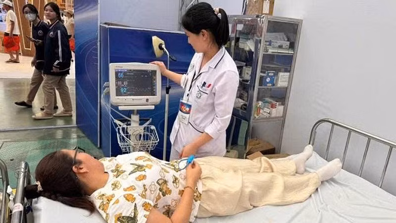 Cán bộ y tế chăm sóc sức khỏe người dân khi tham quan Triển lãm thành tựu đất nước.