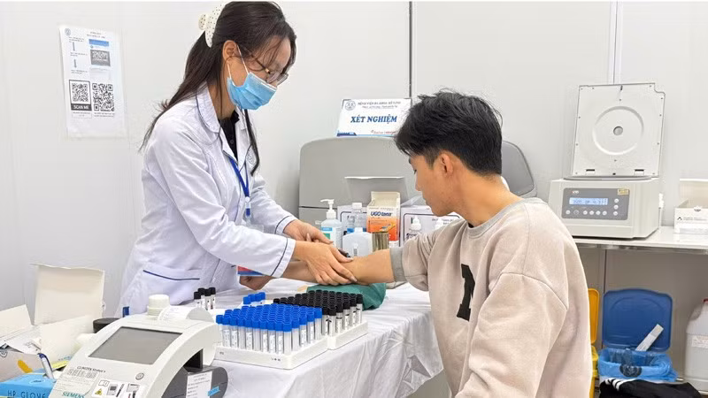 Cán bộ Bệnh viện đa khoa Mê Linh, Hà Nội lấy máu xét nghiệm cho người bệnh. (Ảnh nhandan.vn)
