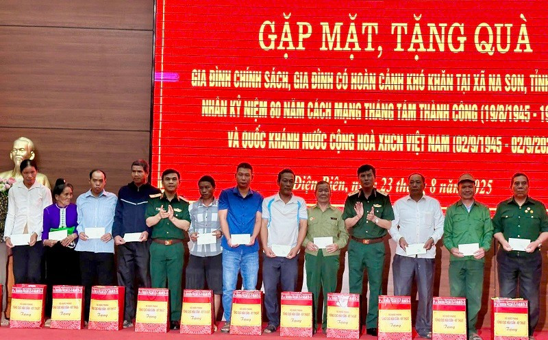 Các đồng chí trong Đoàn công tác Tổng cục Hậu cần-Kỹ thuật Bộ Quốc phòng trao quà tặng các gia đình chính sách, hộ nghèo ở xã Na Son. 
